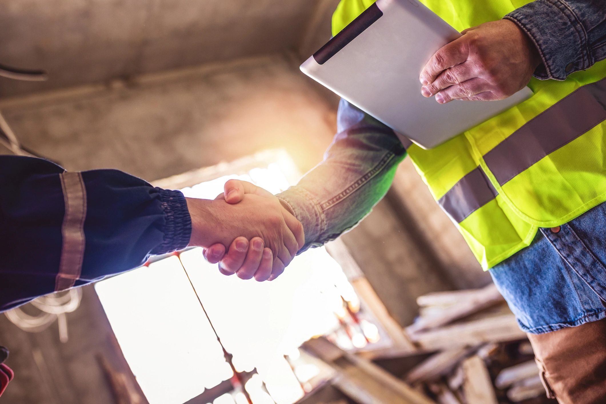 Contractor and client shaking hands at a construction site