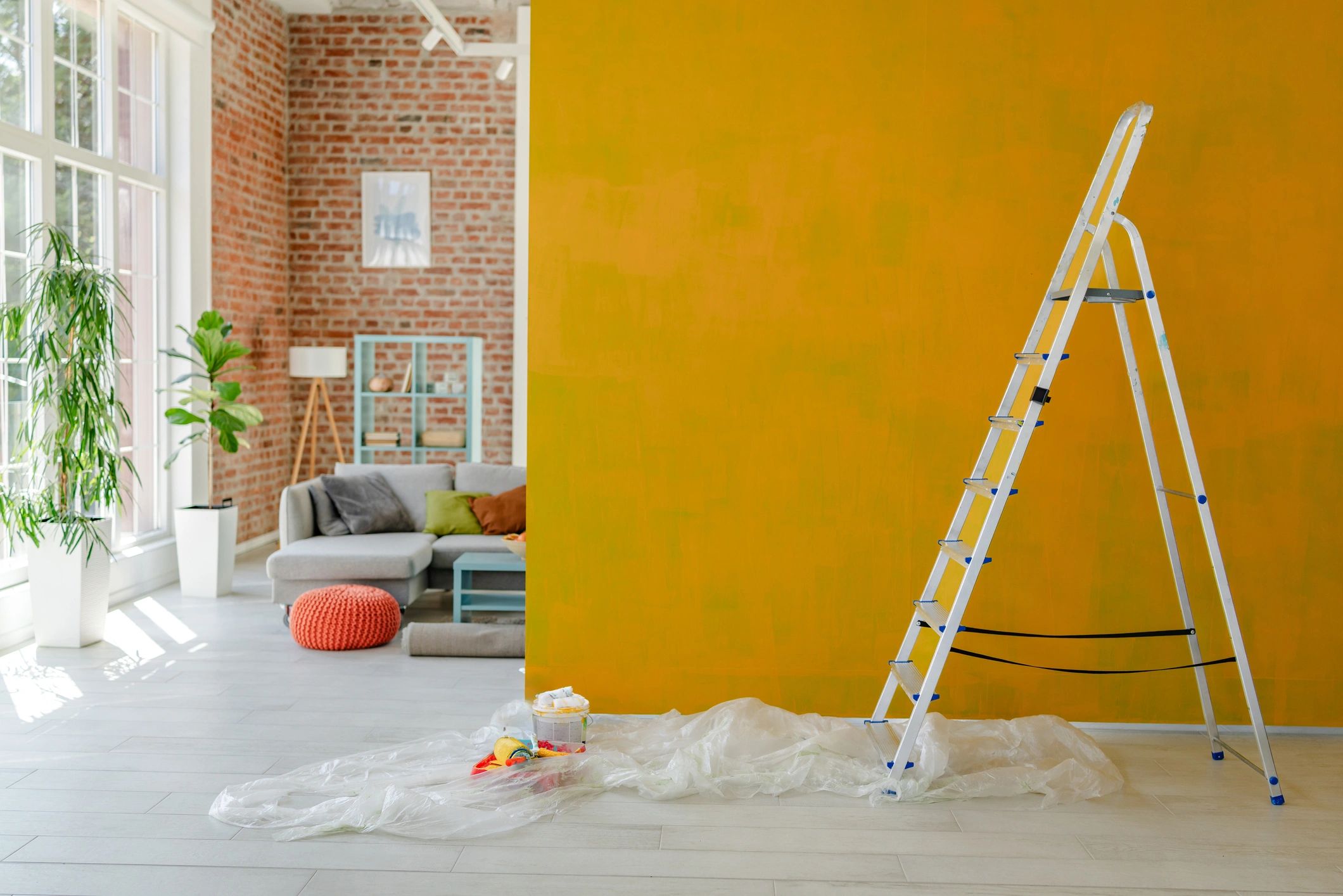 Home improvement project with ladder beside painted wall